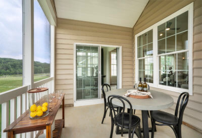 Screened in Porch of The Adams Model with a table and chairs