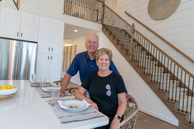 Couple sitting at an island in a kitchen with white cabinets