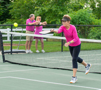 55+ active adult resident playing pickleball