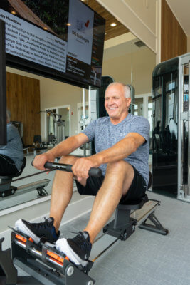 man working out on a rowing machine in a traditions of America community gym