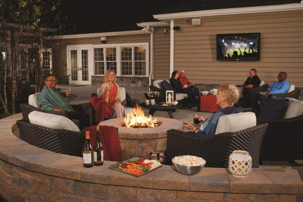 People sitting at the fire pit on a Traditions of America clubhouse patio