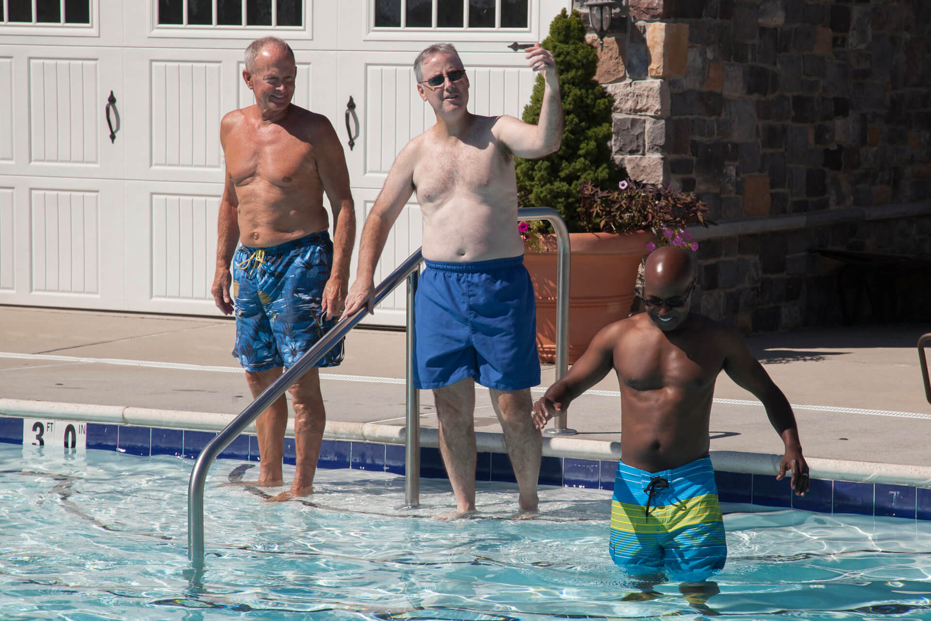 Three men walking down the stairs of a pool from Traditions of America
