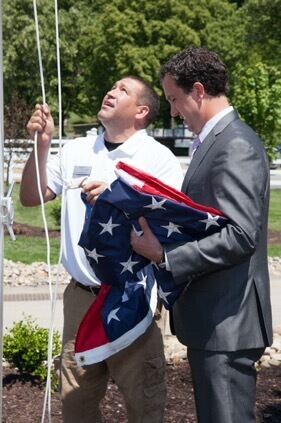 Dan, community manager at Traditions of America Summer Seat, raising the flag at Summer Seat