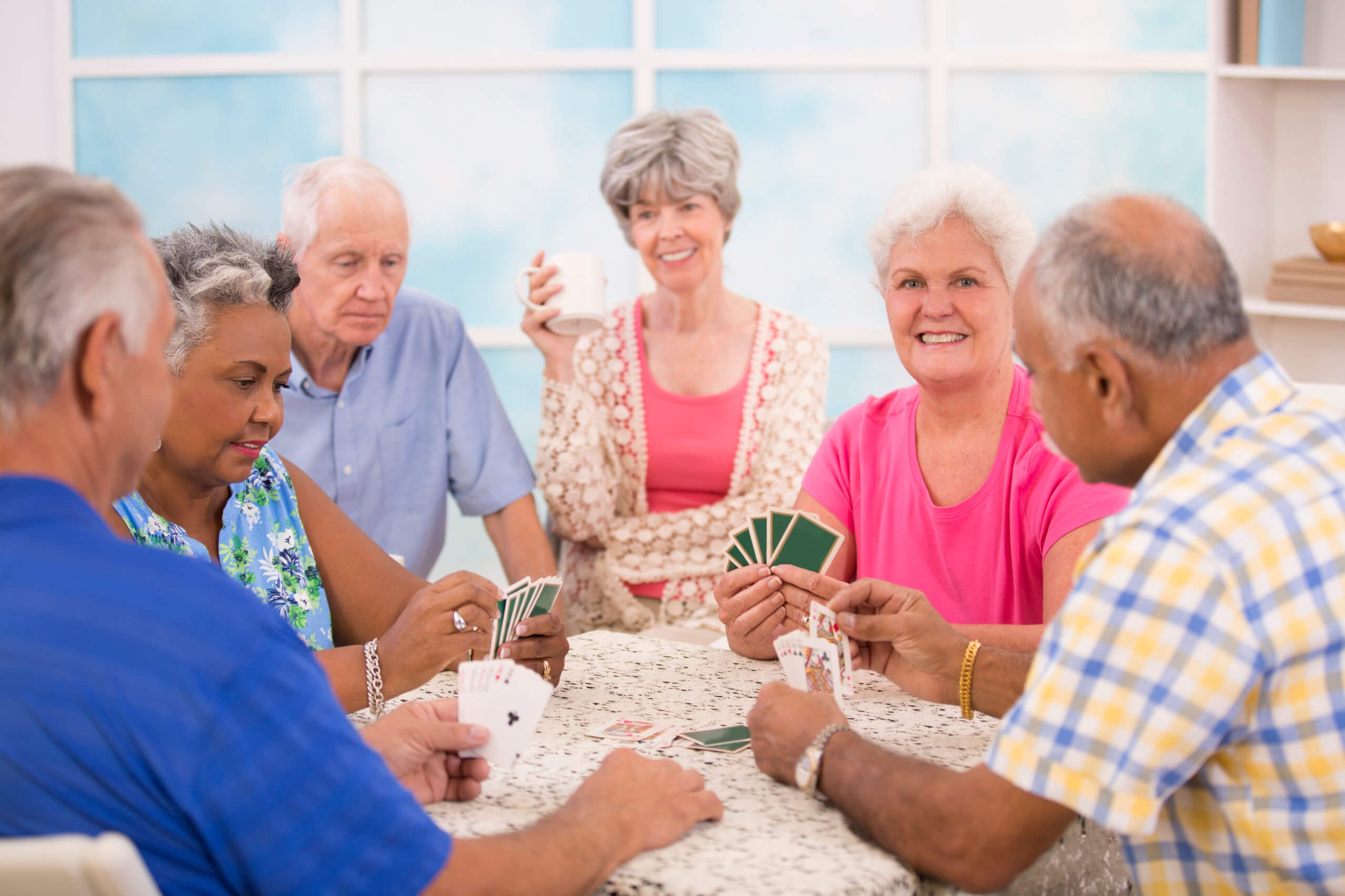 Senior adult friends playing cards. Home or community center setting.