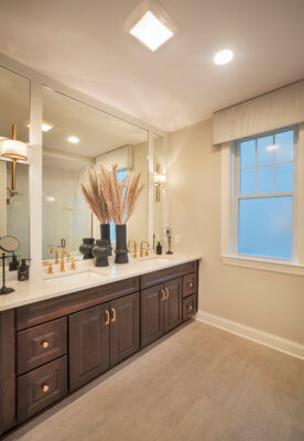 Bathroom with brown cabinets and two sinks in a Franklin model