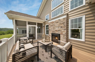 Deck with outdoor fireplace and a screened in section on the Franklin model