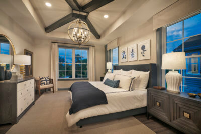 Master bedroom with chandelier and large windows in the Grant model