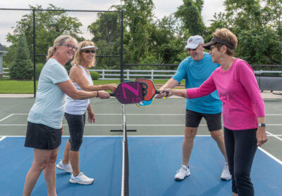 residents starting pickleball game at active adult community pickleball court