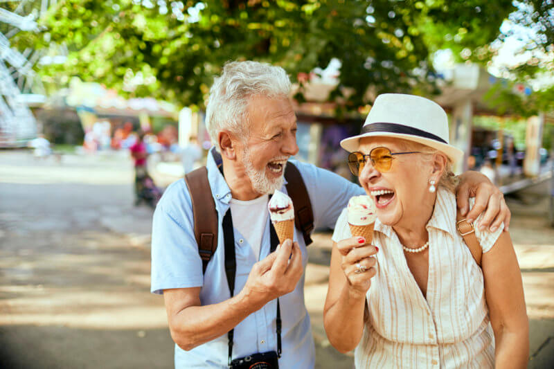 Two active adults laughing and eating ice cream