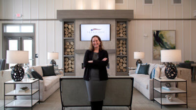 Staff Member Posing In front of Living room Set up