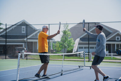Two active adults greeting each other before a pickle ball match