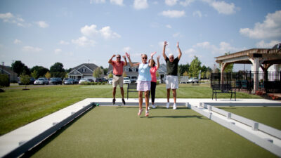 Four People Celebrating On a Turf Area