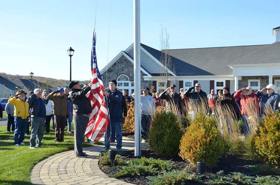 People standing outside while raising the flag