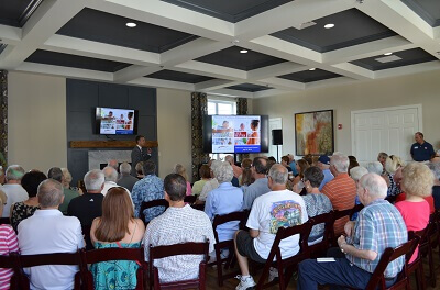 People sitting in the Traditions of America clubhouse watching a presentation