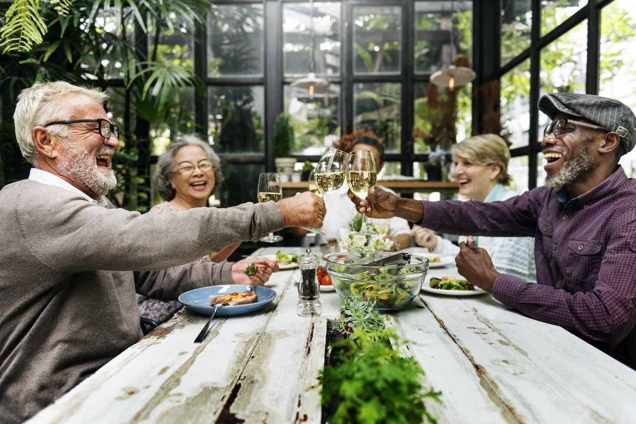 Group of People Out to Dinner Cheersing