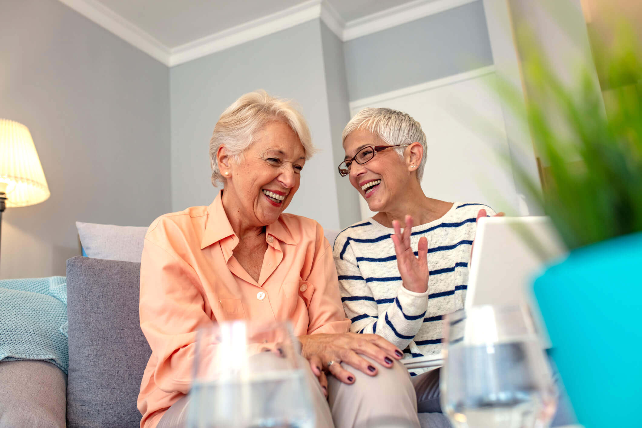 Two active adult women talking on the couch