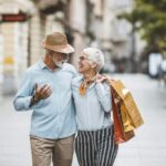 An active adult couple walking down the side walk in a city
